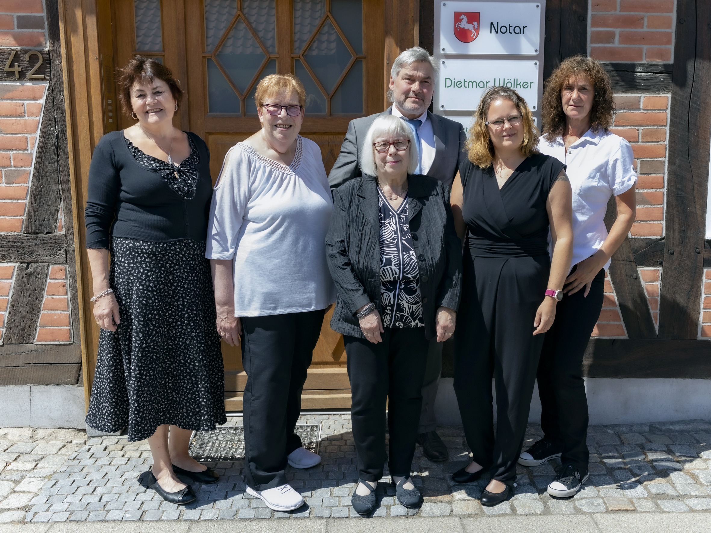 Das Team der Kanzlei Wölker vor dem Kanzleieingang